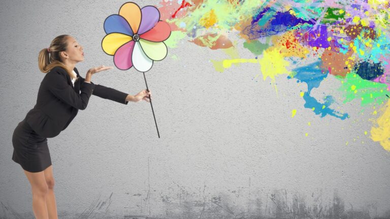 Creativity-Women blowing on pinwheel of colors